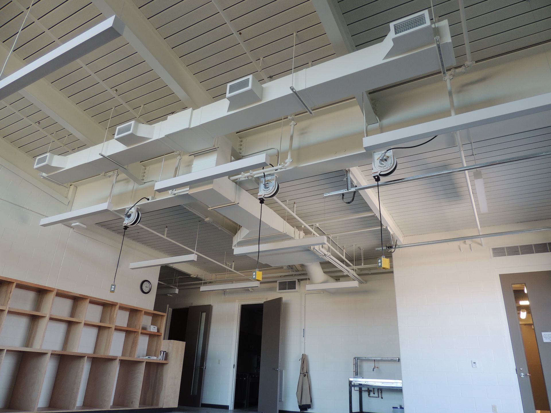 A room with a lot of ducts hanging from the ceiling