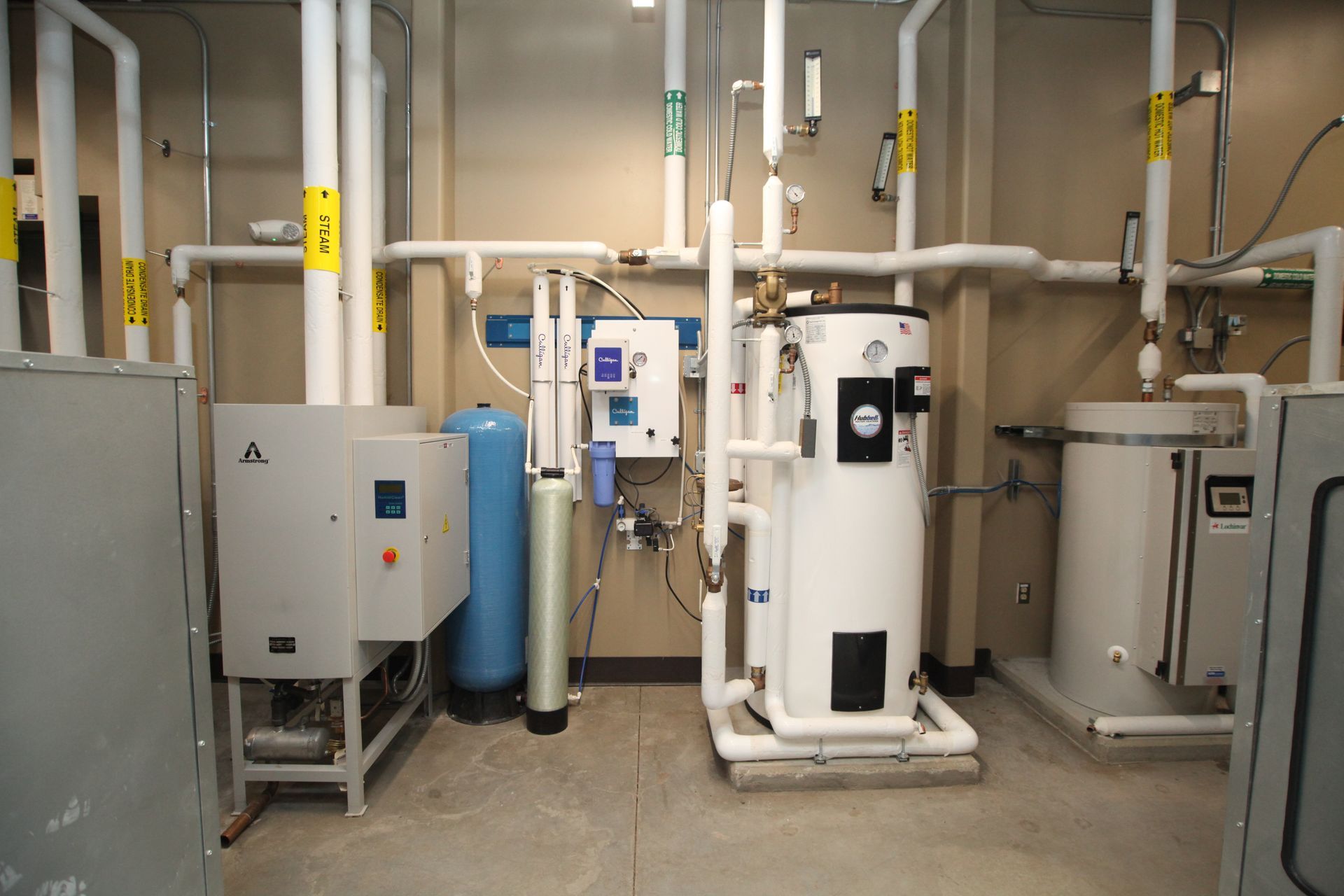 A room with a lot of pipes and a water heater