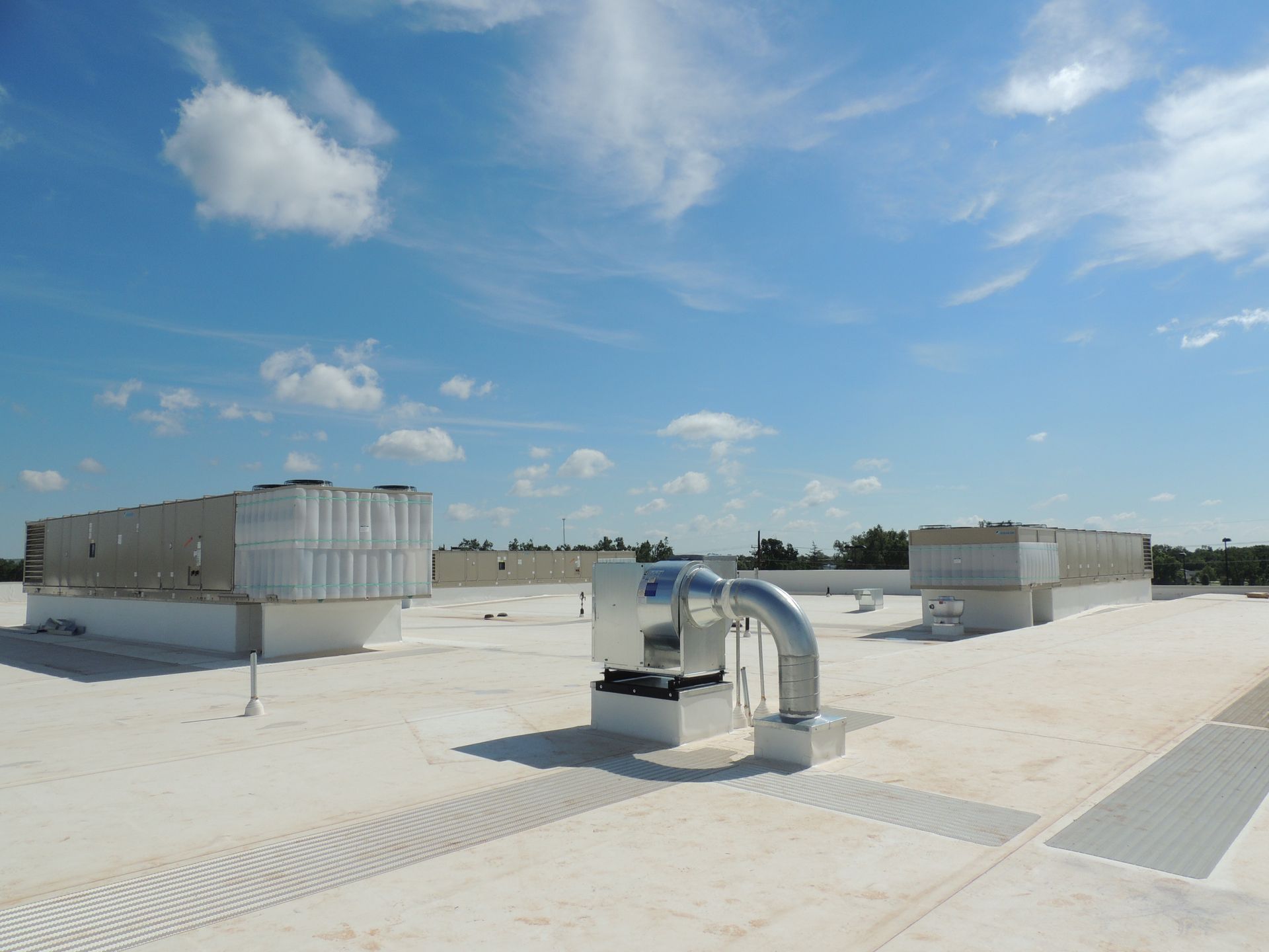 A white roof with a blue sky and clouds in the background