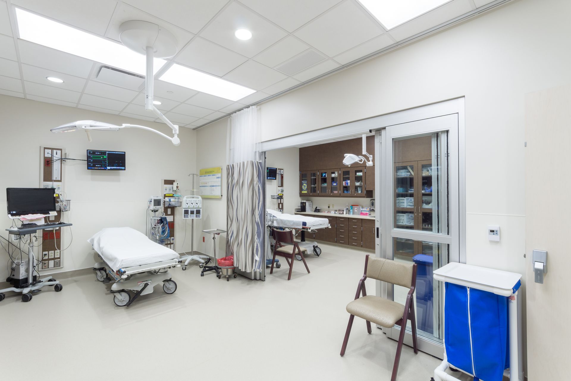 An operating room in a hospital with a bed and chairs.