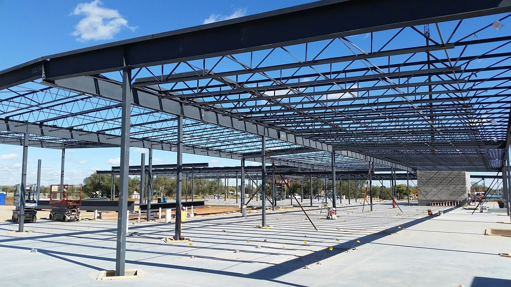 A large metal structure is being built on a sunny day.