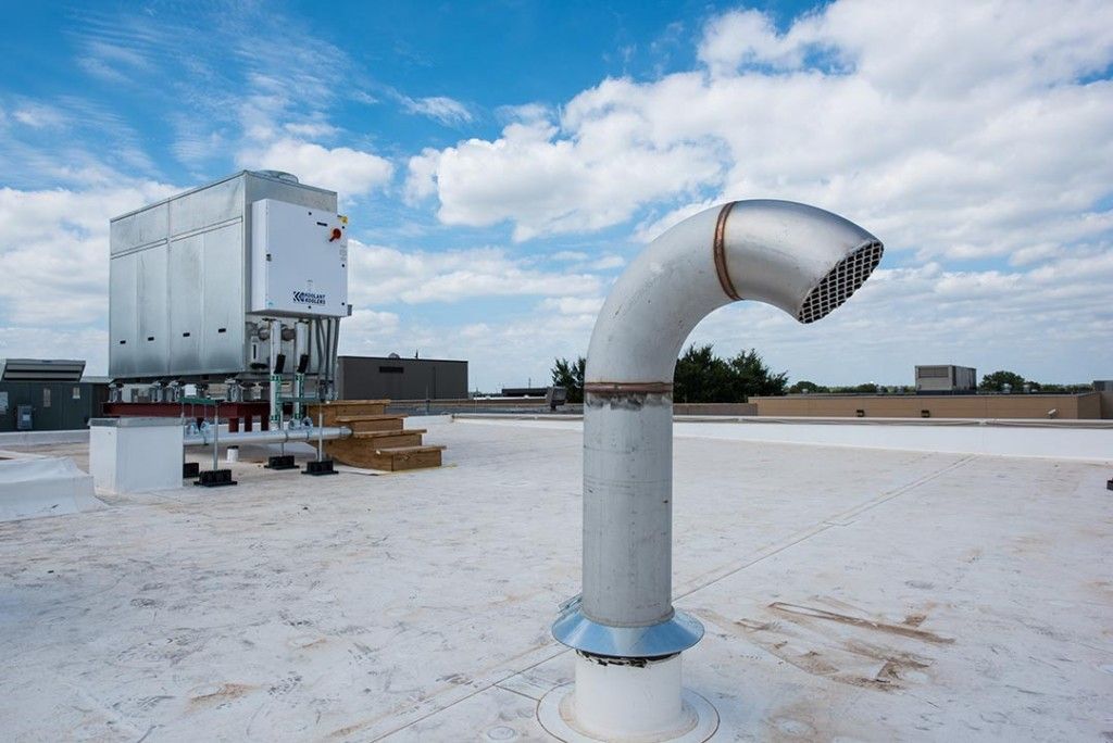 A white roof with a metal pipe on it