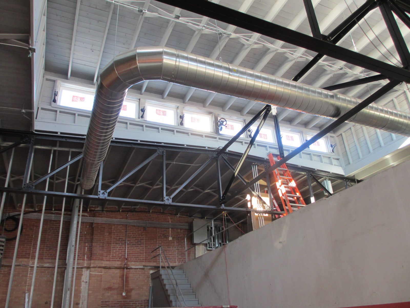 A ladder is hanging from the ceiling of a building under construction