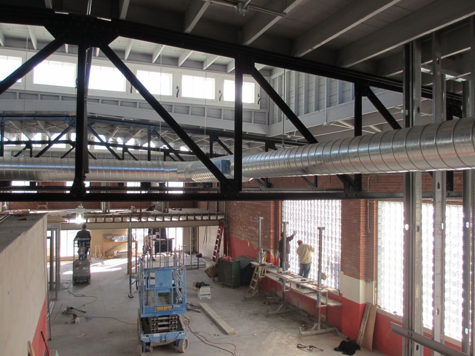 The inside of a building under construction with a blue crane in the middle