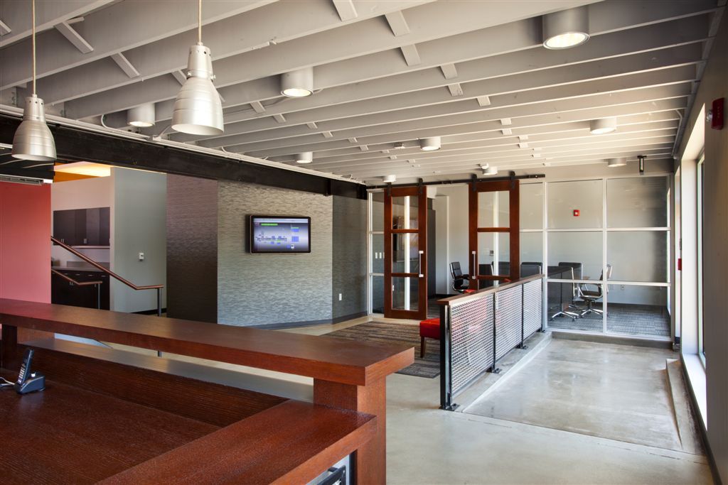 A large room with a table and a television on the wall