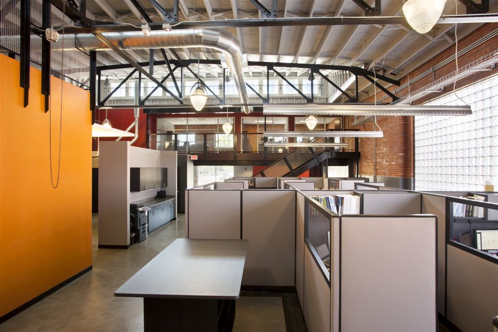 An empty office with cubicles and a large window