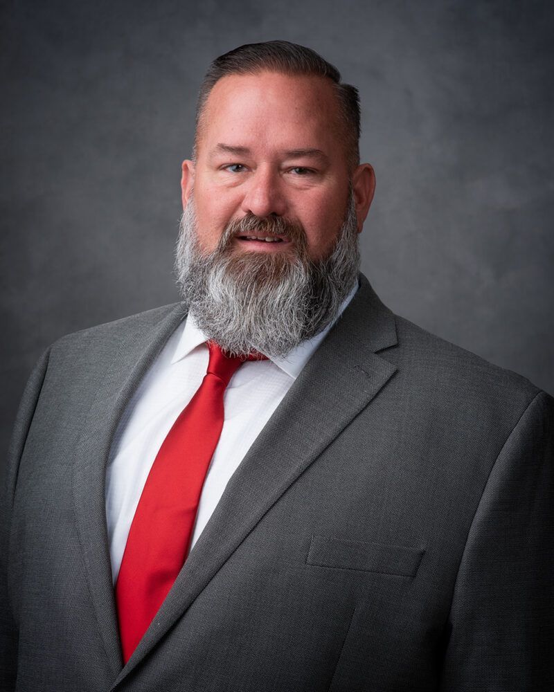 A man with a beard is wearing a suit and tie.