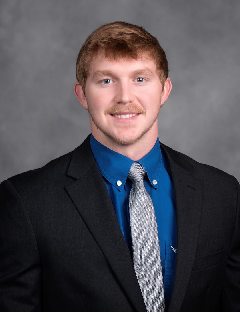 A man in a suit and tie is smiling for the camera.
