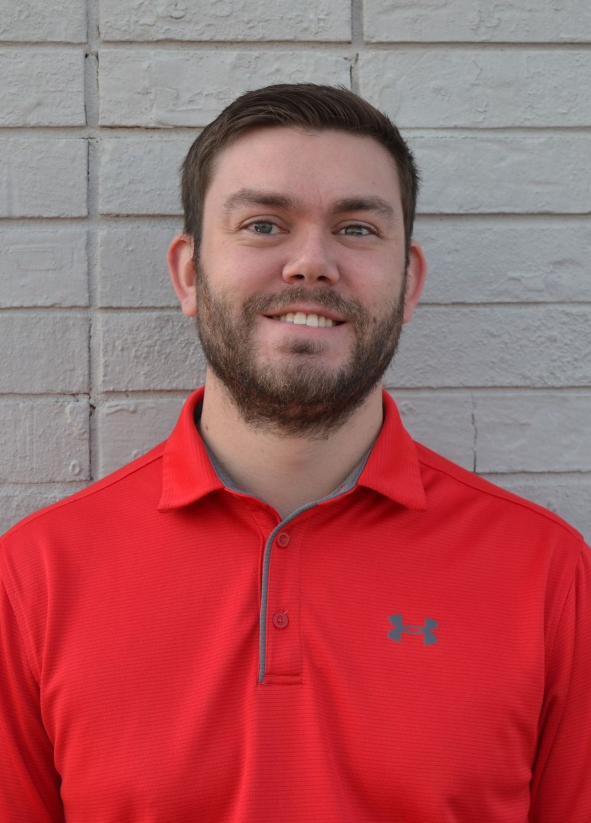 A man in a suit and tie is smiling for the camera