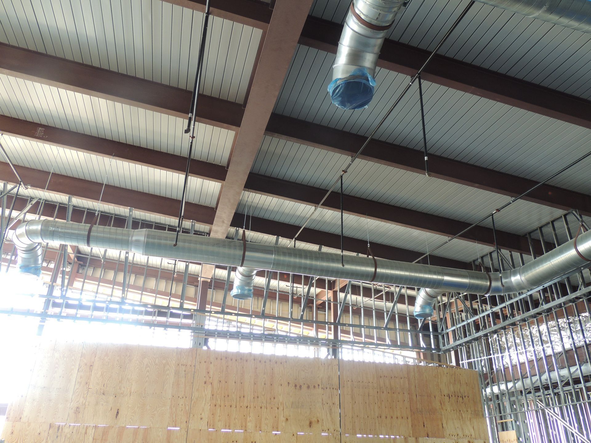 A ceiling with a lot of pipes hanging from it