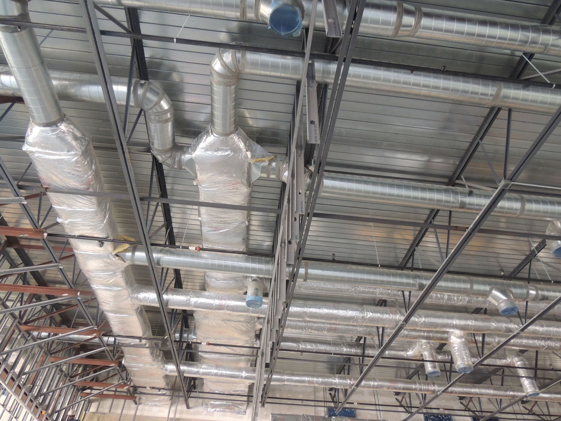 A bunch of pipes are hanging from the ceiling of a building.