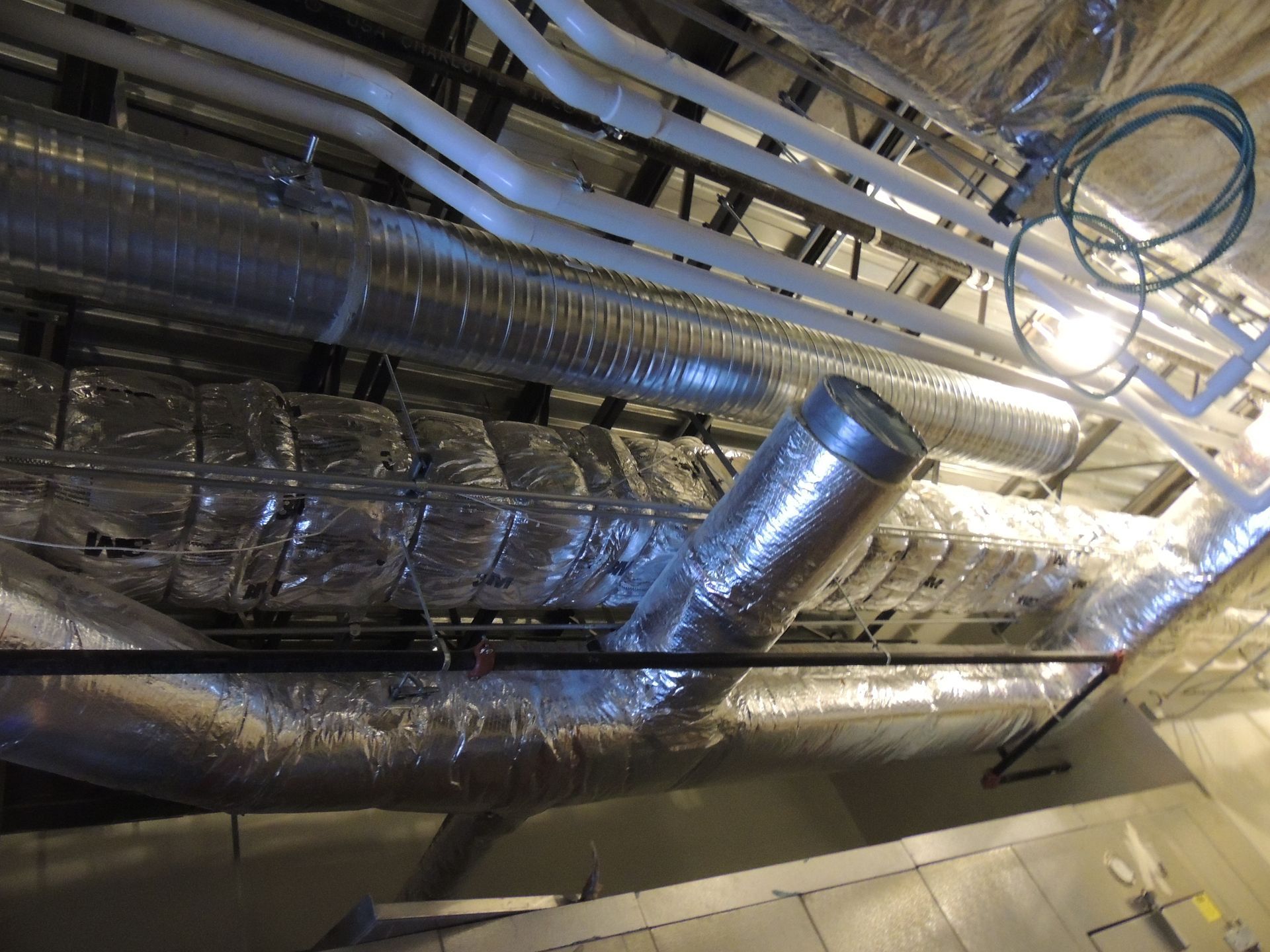 A room with a lot of pipes hanging from the ceiling