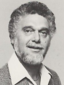 A black and white photo of a man with a beard.