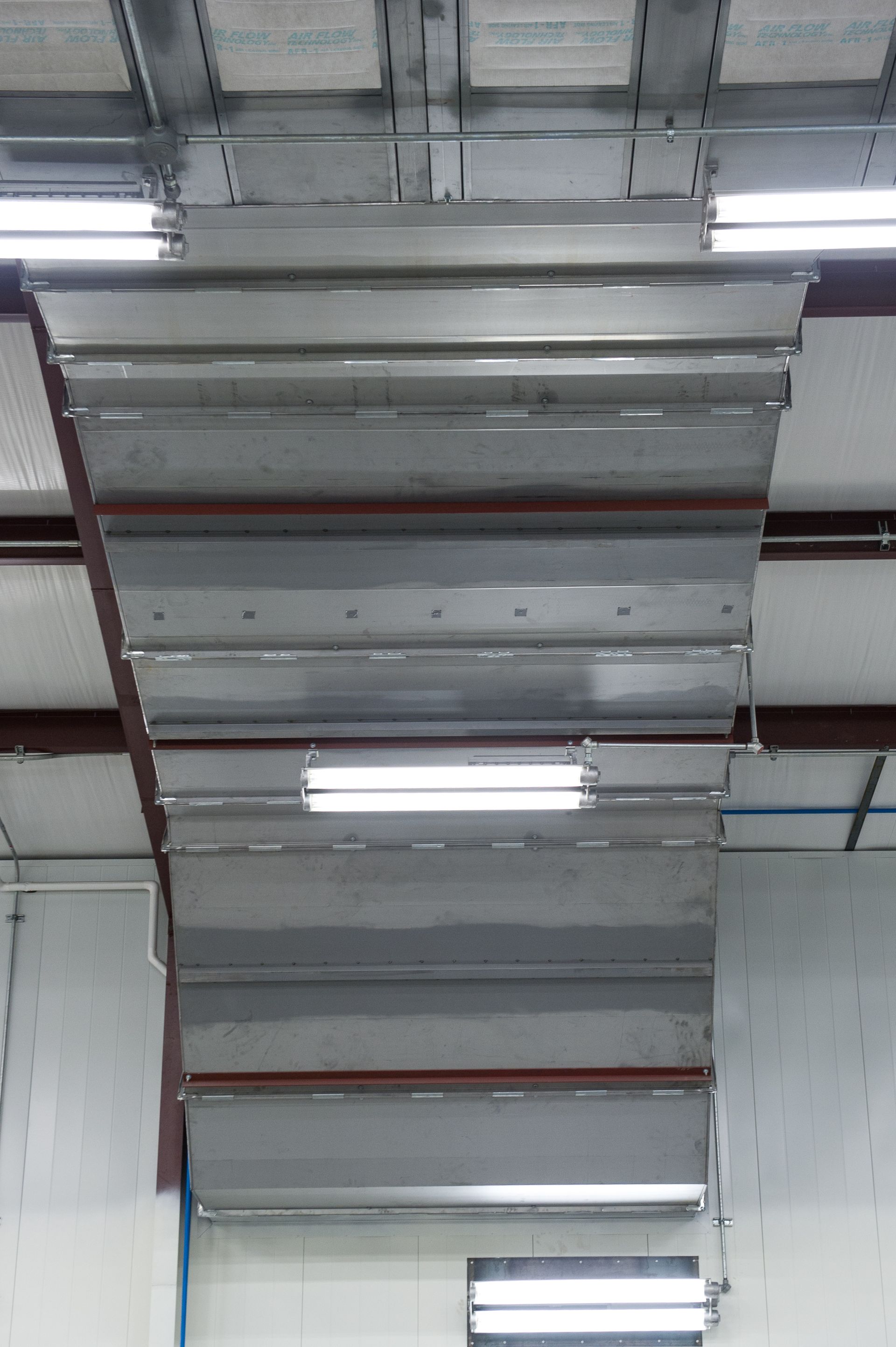 A large metal pipe is hanging from the ceiling of a building.