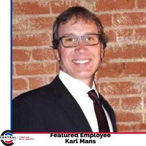 A man in a suit and tie is featured employee karl mans