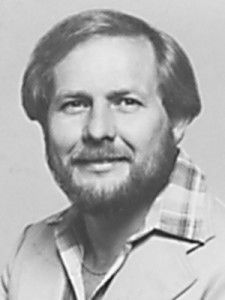A black and white photo of a man with a beard wearing a jacket.