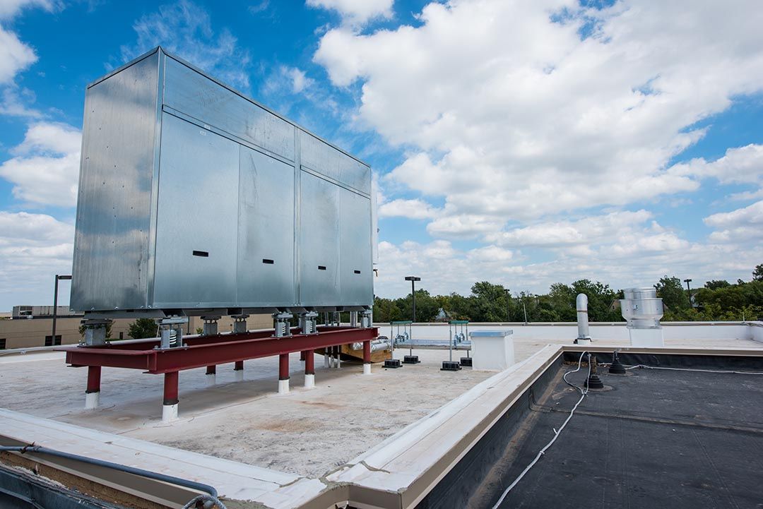 A large metal box is sitting on top of a roof.