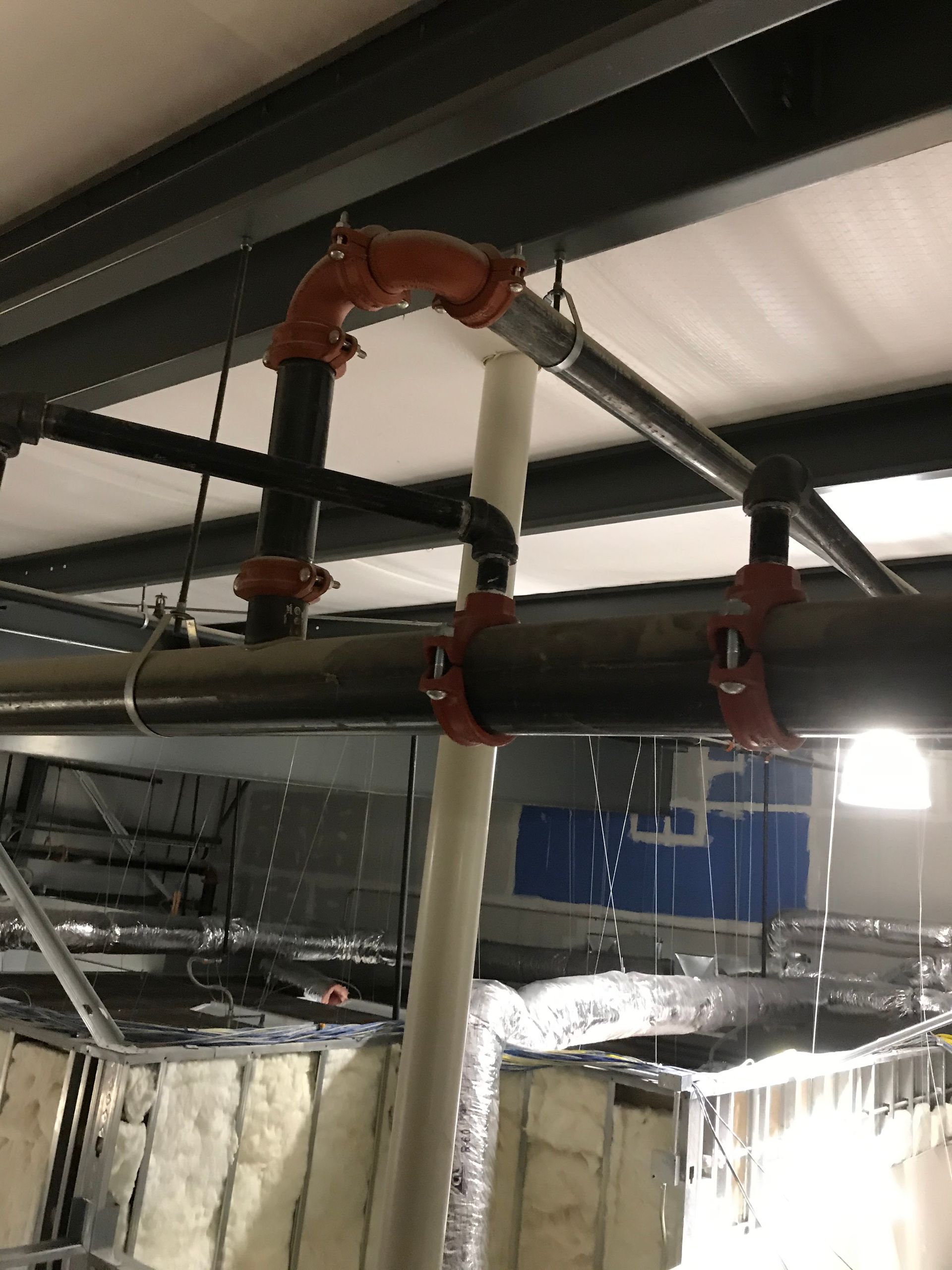 A room with a lot of pipes hanging from the ceiling.