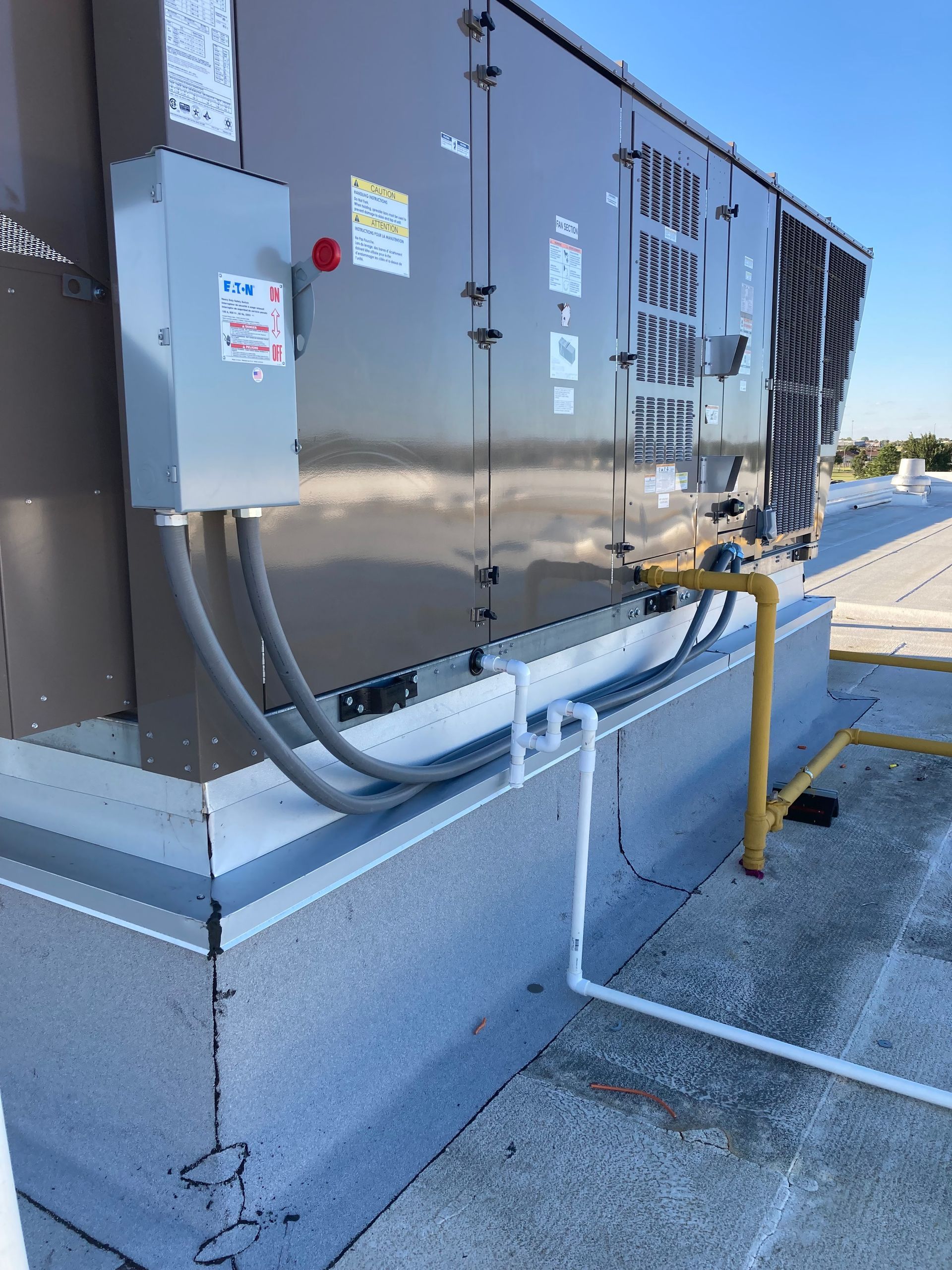 A large electrical box is sitting on the side of a building.