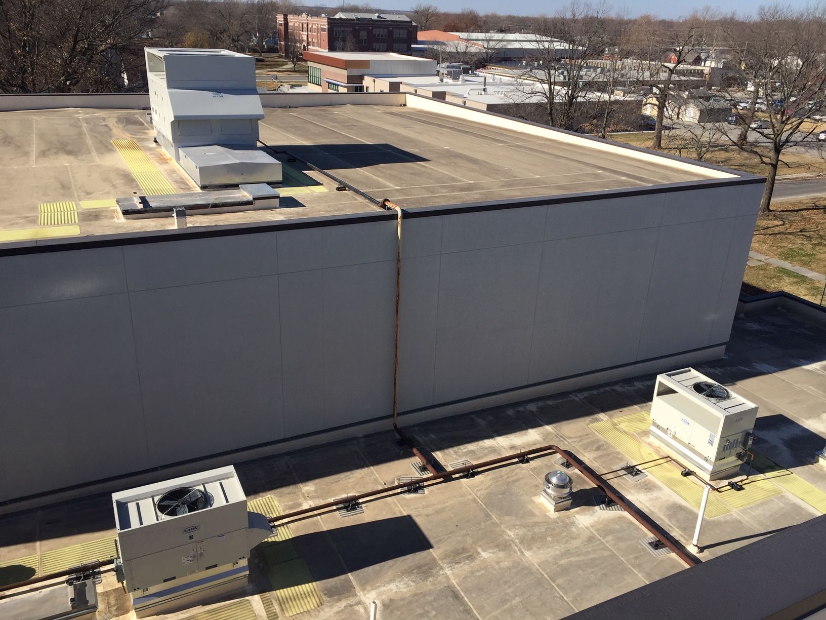 An aerial view of the roof of a building with a lot of air conditioners on it.