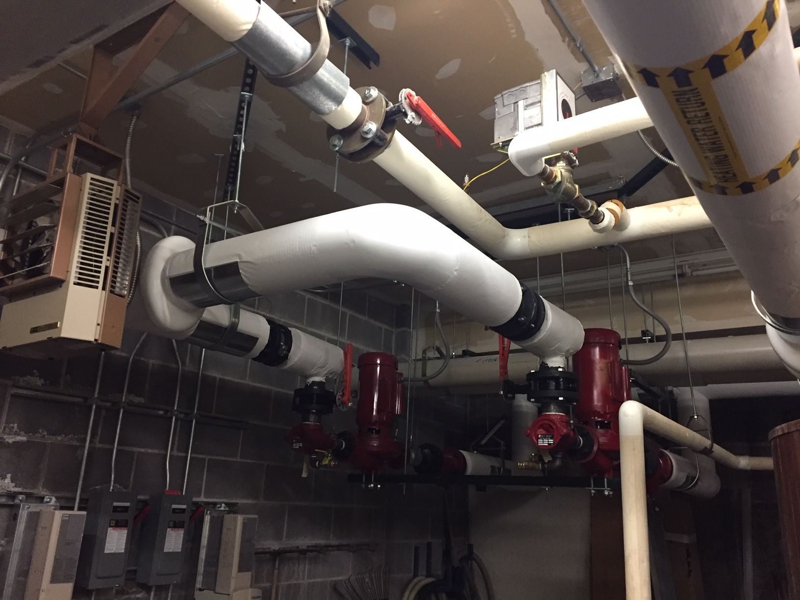 A bunch of pipes are hanging from the ceiling in a room.
