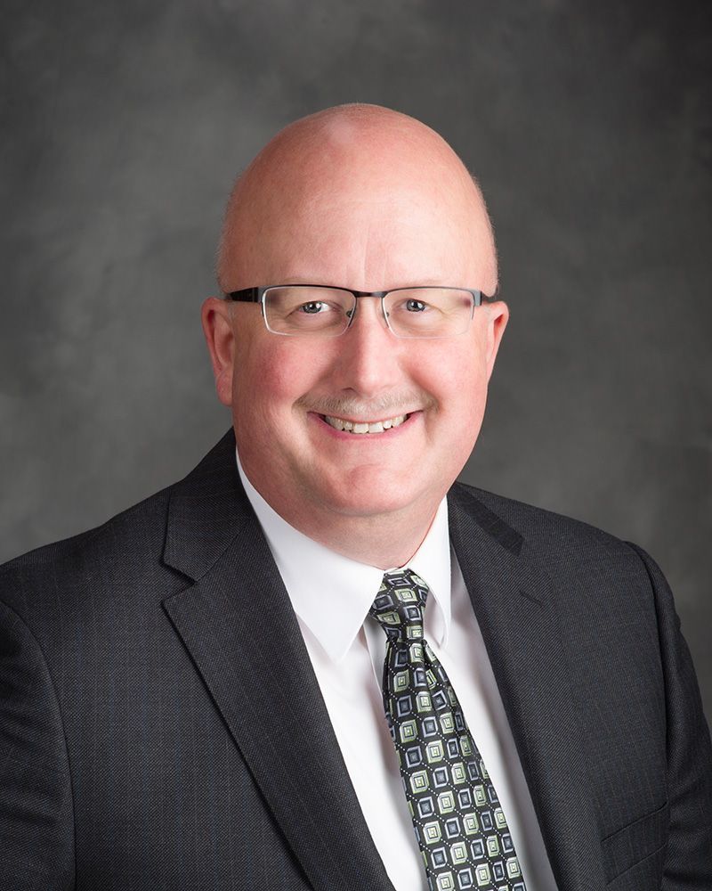 A man named Jack Boucher in a suit and tie is smiling for the camera.