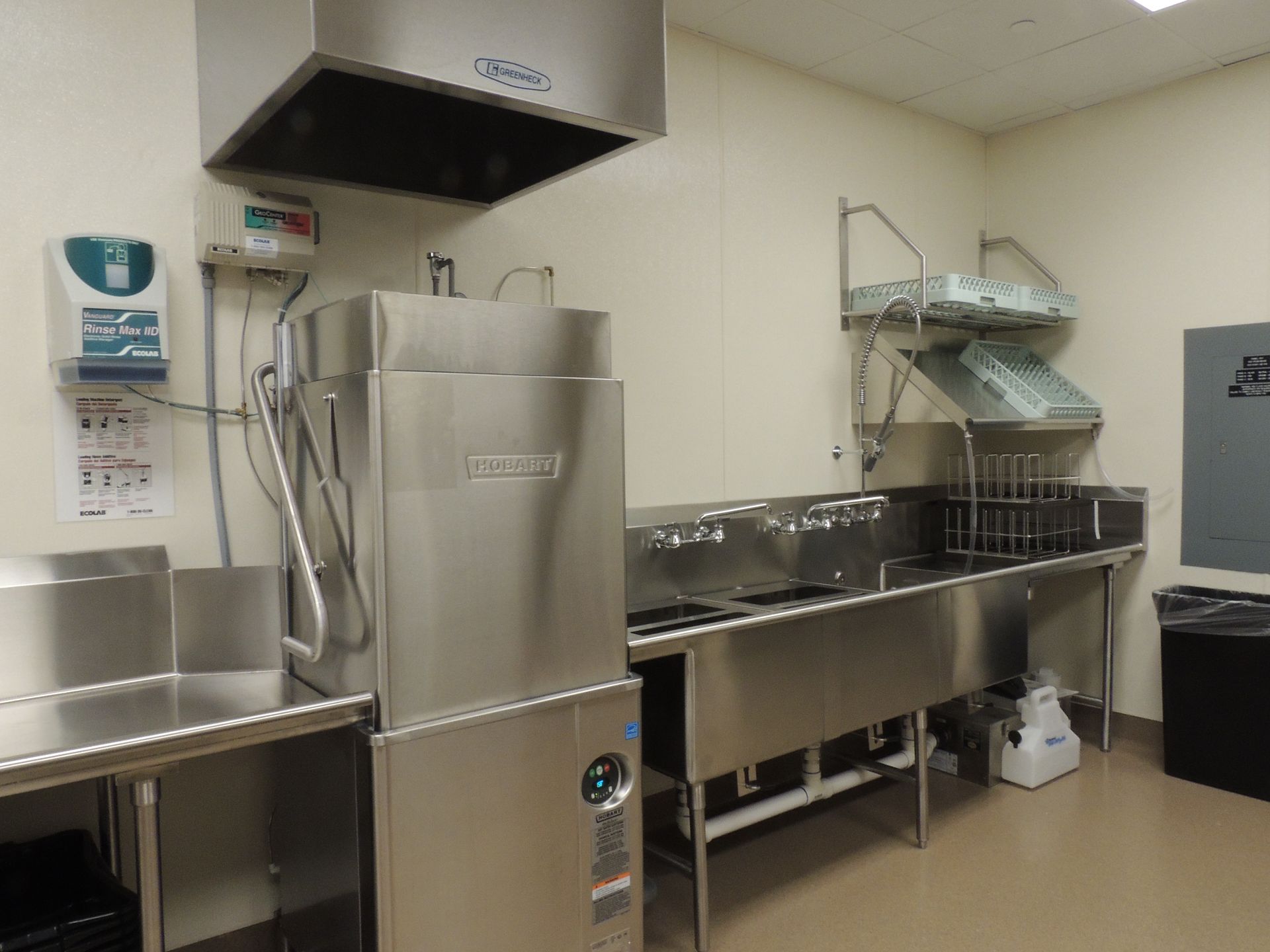 A kitchen with a stainless steel dishwasher and sinks