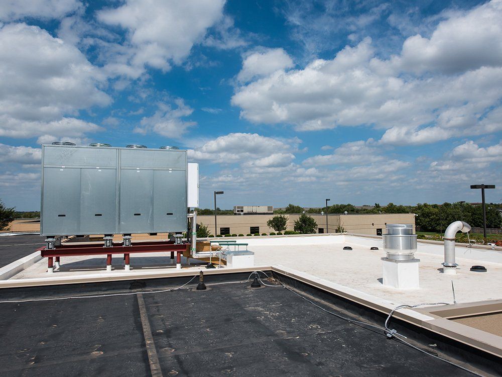 The roof of a building with a blue sky and clouds in the background