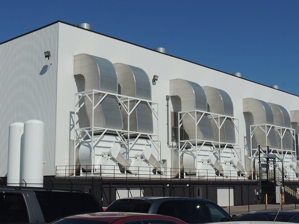 A white building with a lot of pipes on it