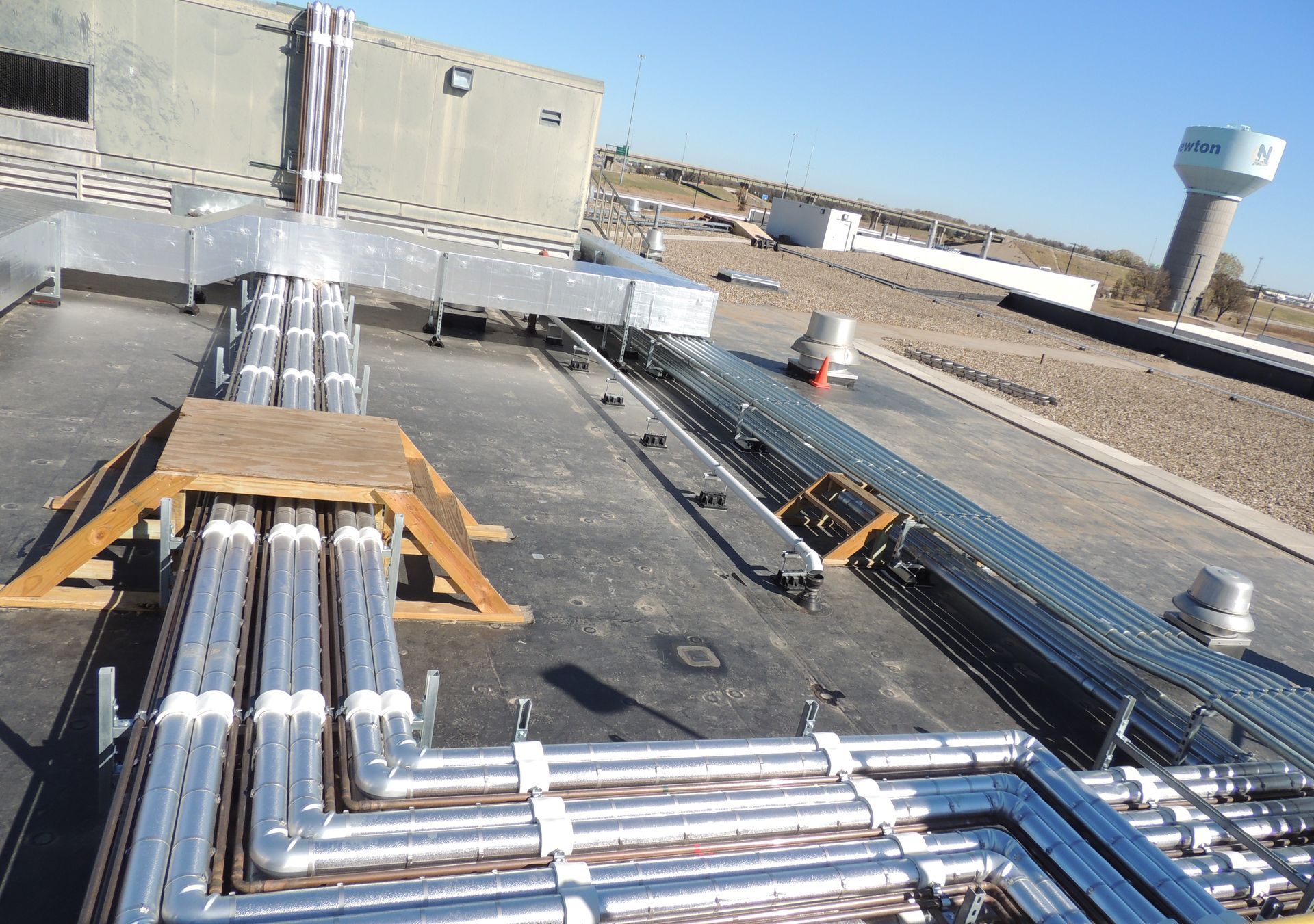 A bunch of metal pipes are sitting on top of a roof