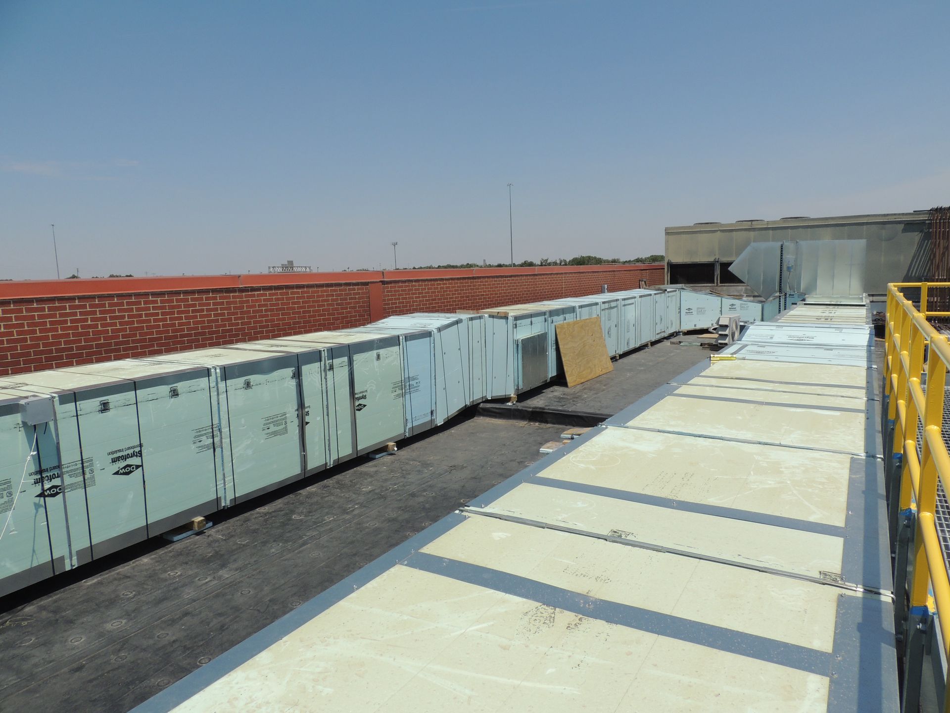 A roof with a lot of boxes on it and a yellow railing