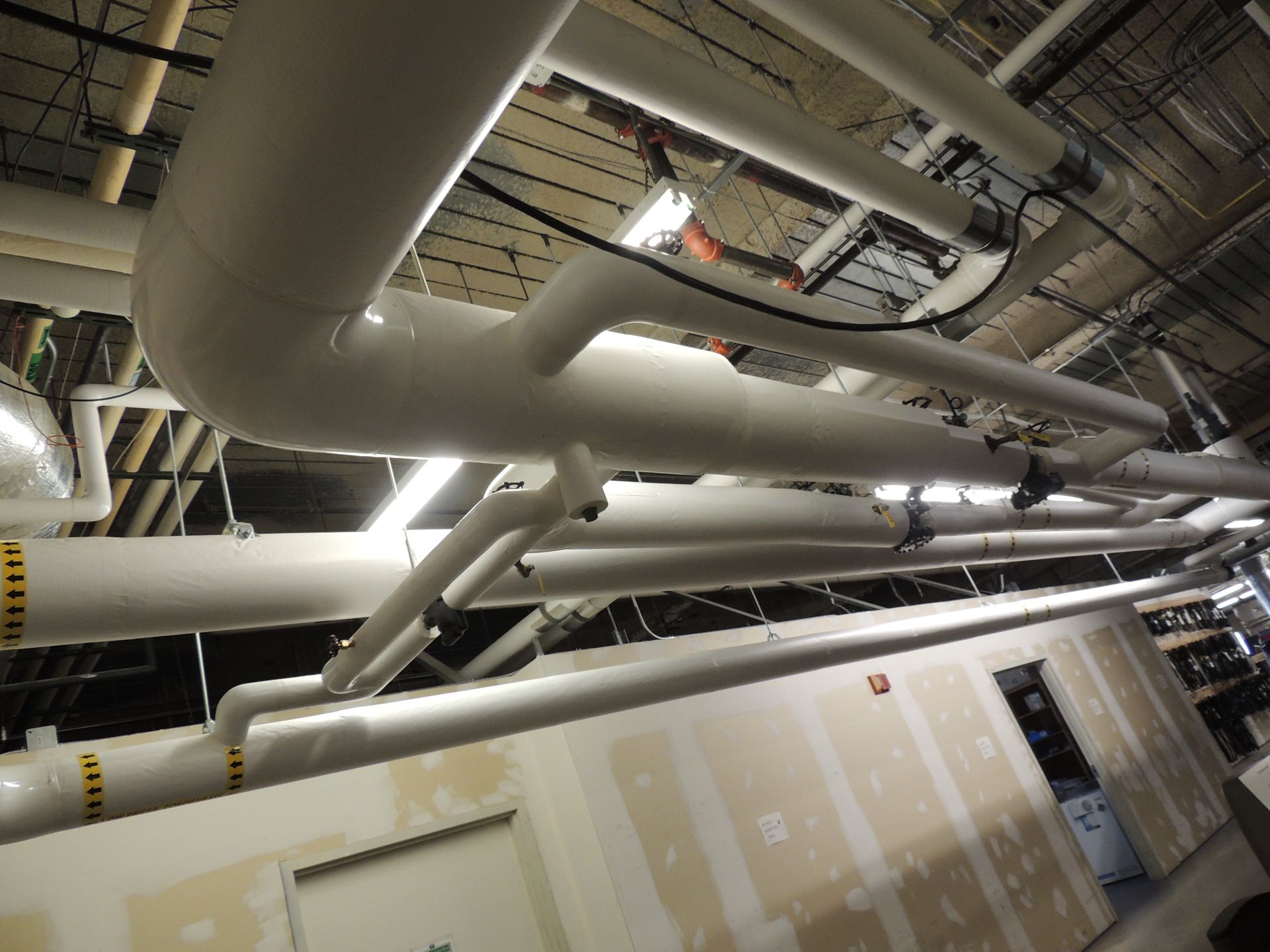 A room with a lot of pipes hanging from the ceiling