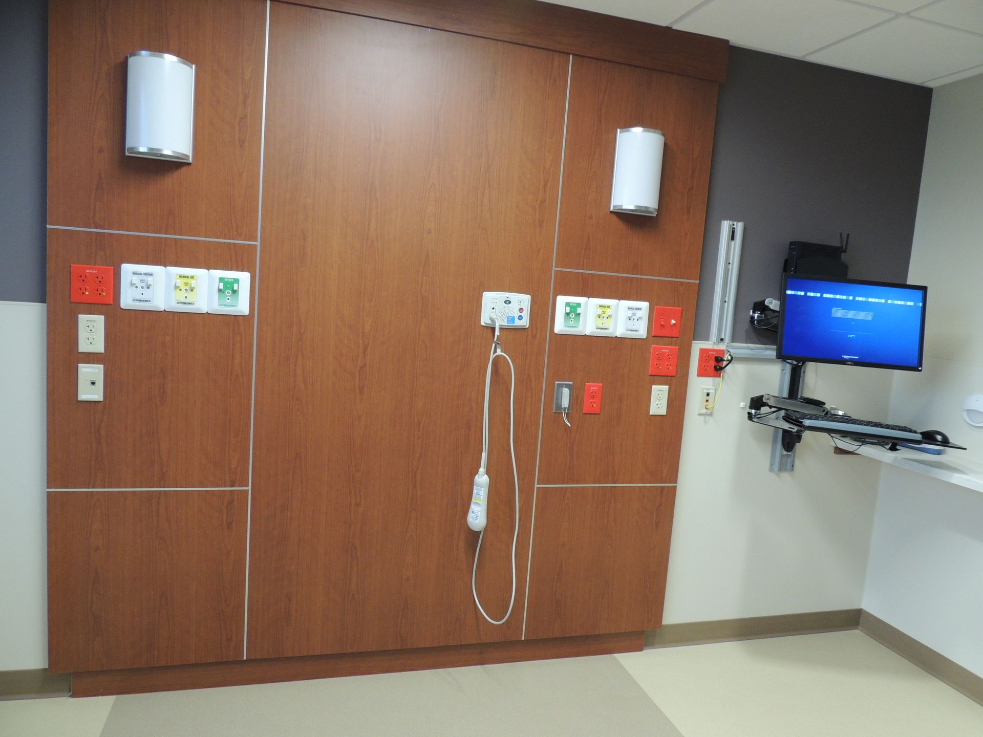 A hospital room with a large wooden wall and a monitor