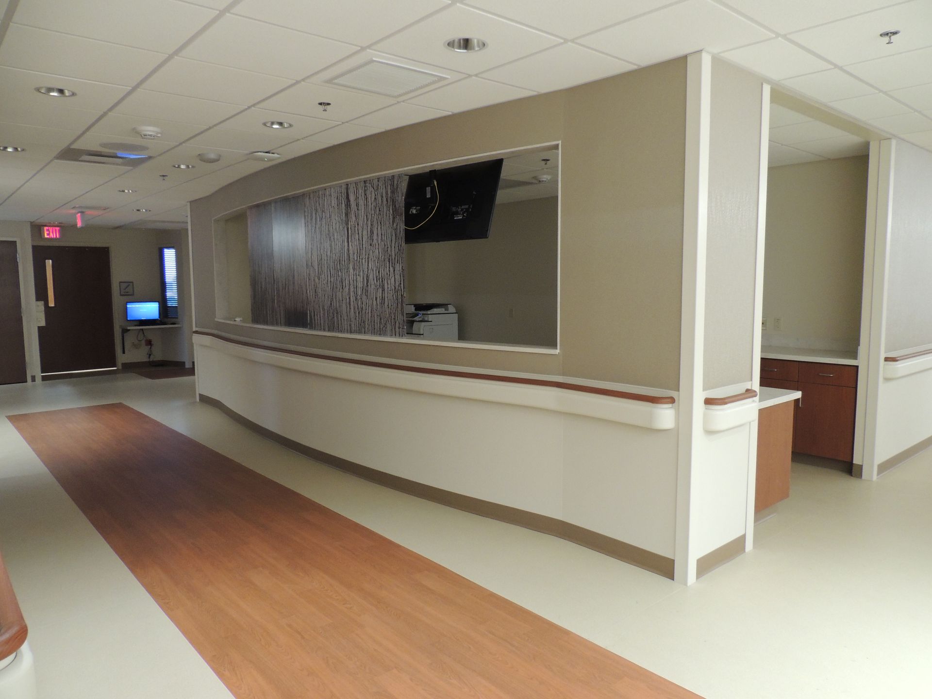 A hospital hallway with a curved counter and a large window