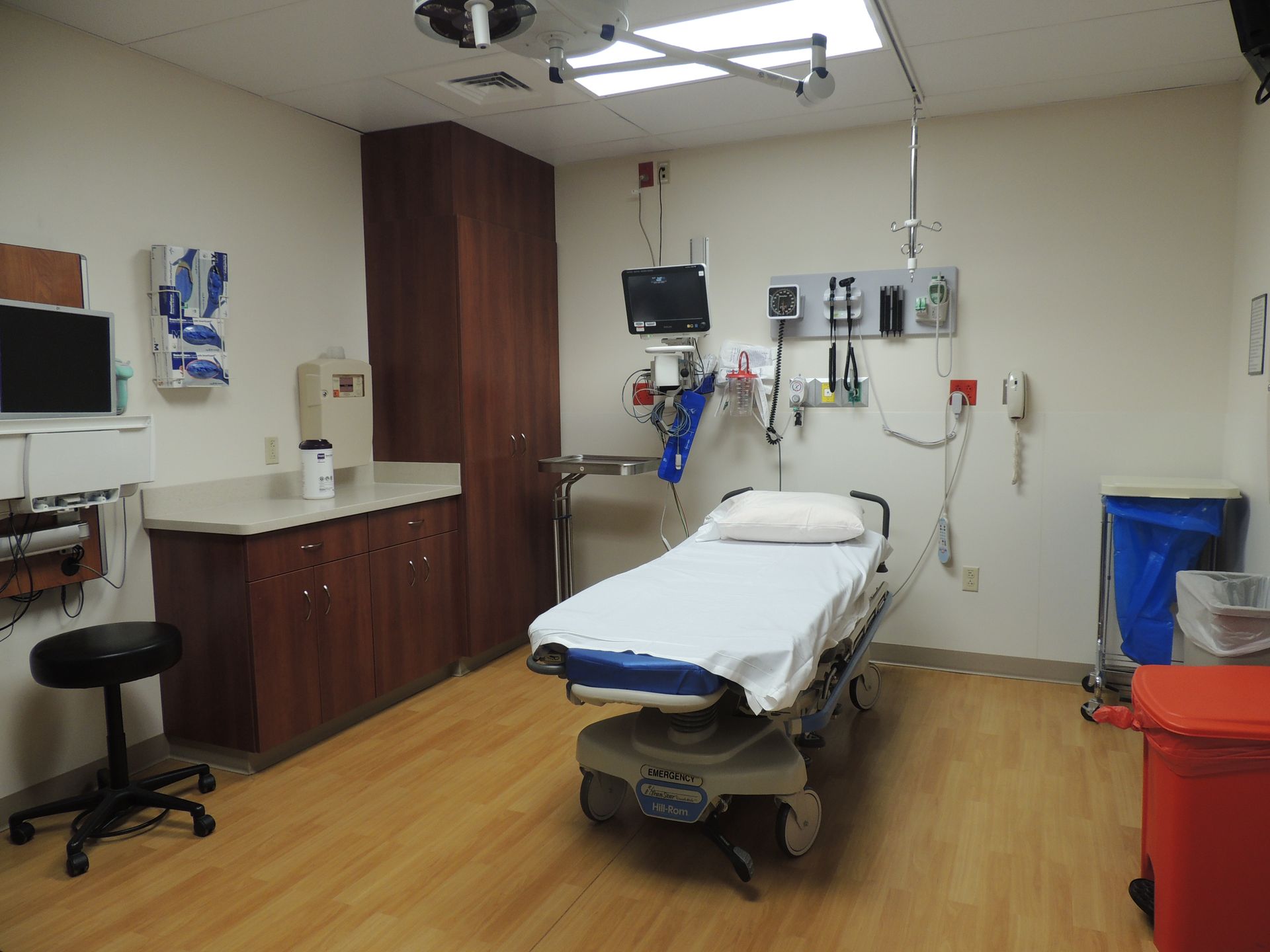 A hospital room with a stretcher and a monitor on the wall.