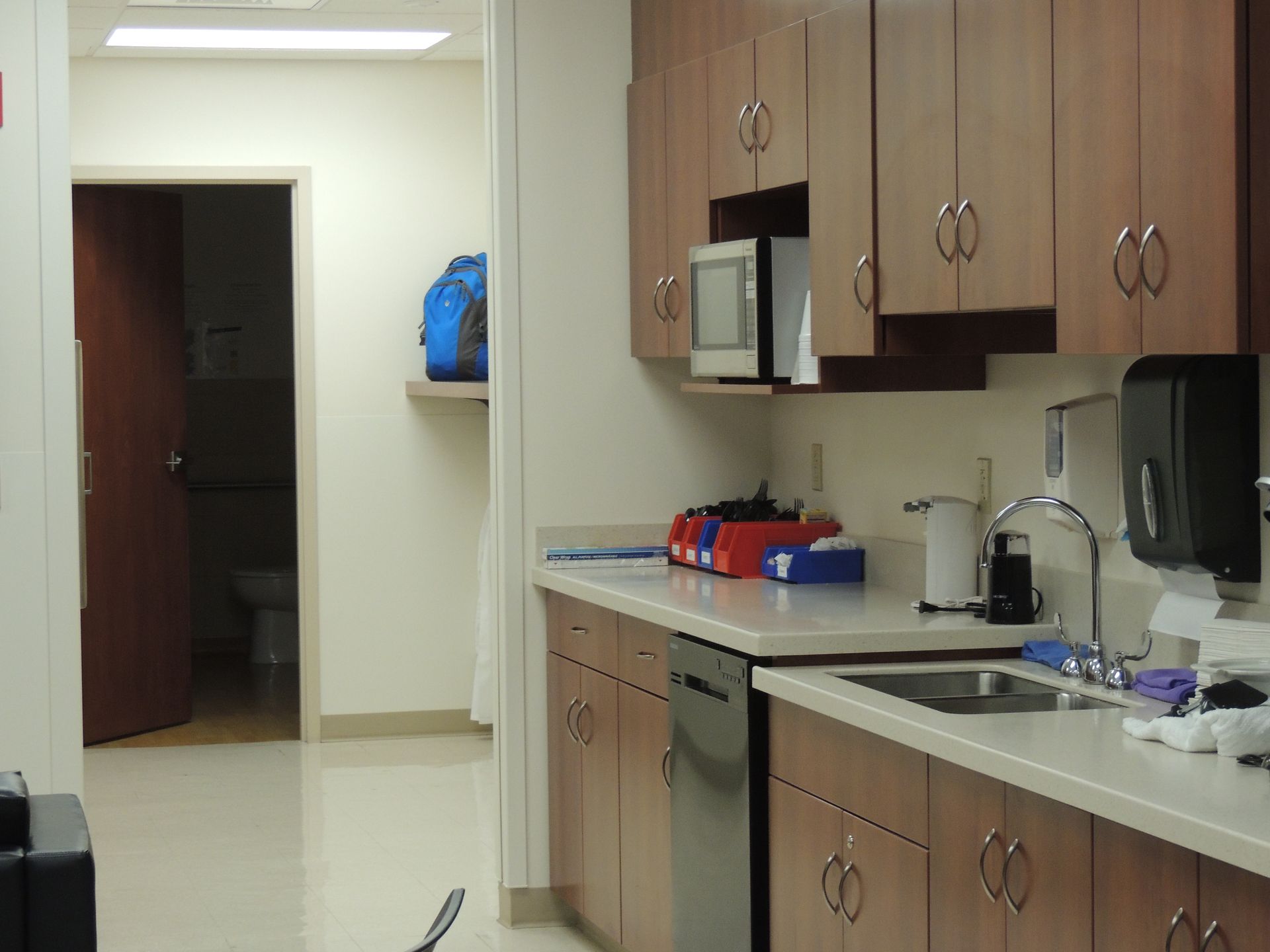 A kitchen with wooden cabinets , a sink , and a microwave.