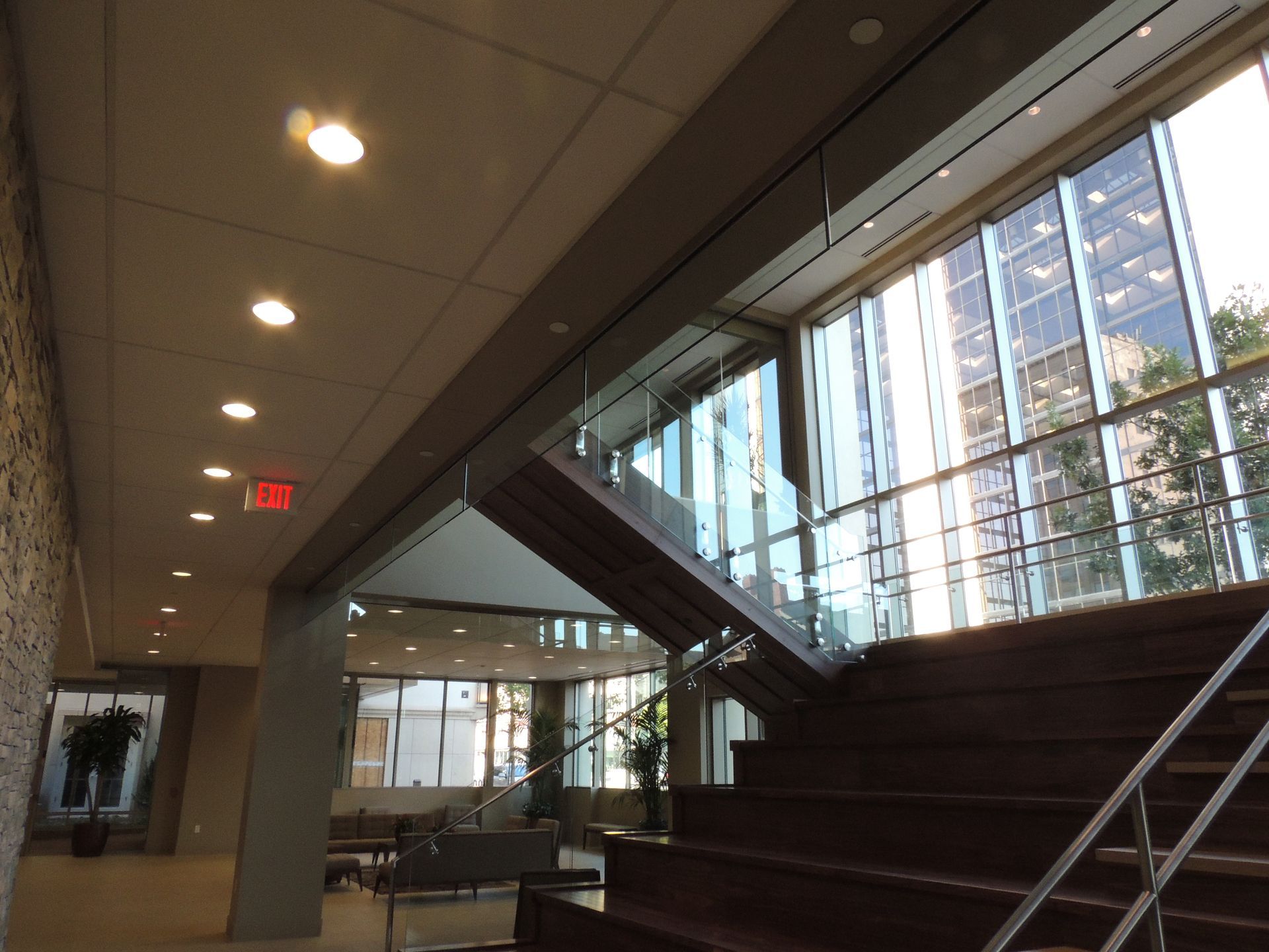 A staircase in a building with a red exit sign