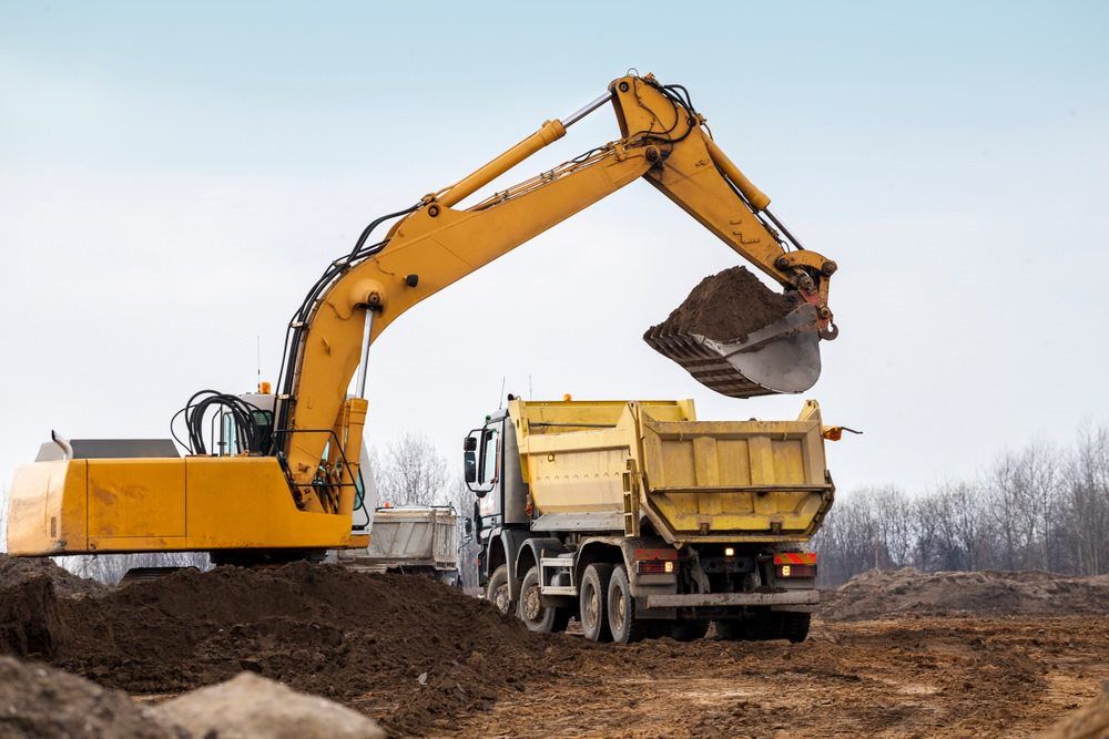 Digger Loading Trucks With Soil — Mining in Moranbah, QLD