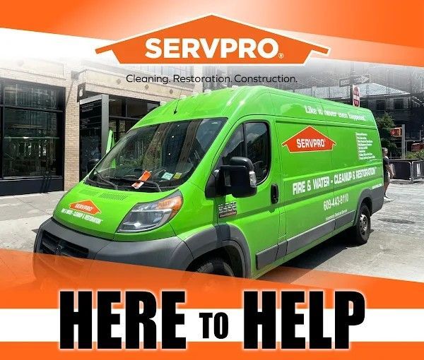 Servpro van in a city setting, advertising fire and water restoration services. Bright green van with 