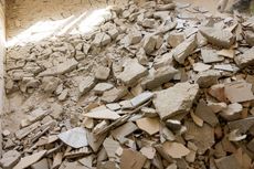 Pile of broken concrete debris filling a room, likely demolition.