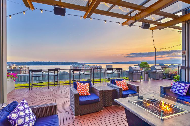 There is a fire pit on the patio with a view of the ocean.