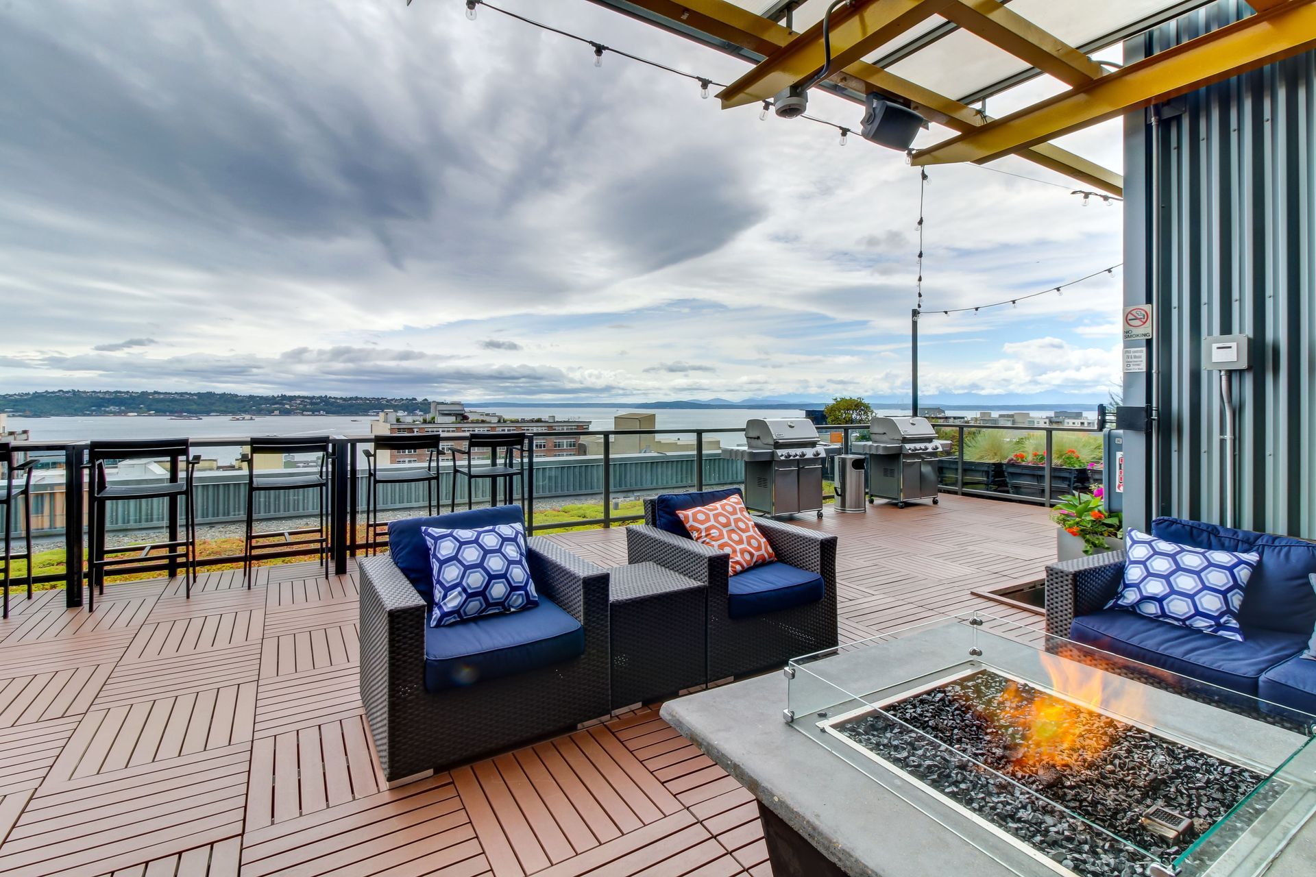 There is a fire pit on the patio with chairs and tables.