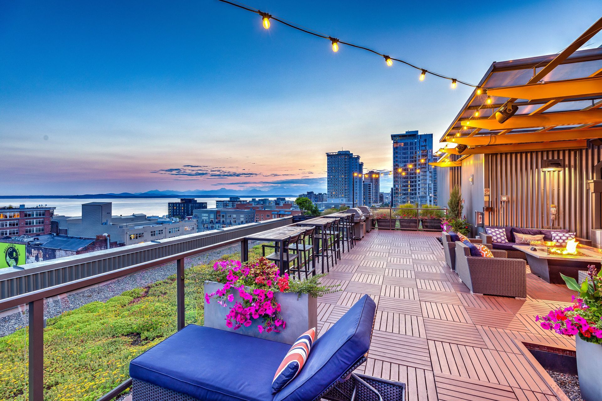 A rooftop deck with a view of the city at sunset.
