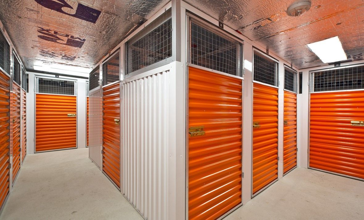 A row of orange storage lockers in a room.