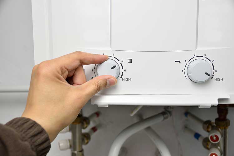 Hand Adjusting the Water Heater Temperature — Santa Rosa, CA — Action Plumbing & Heating Maintenance
