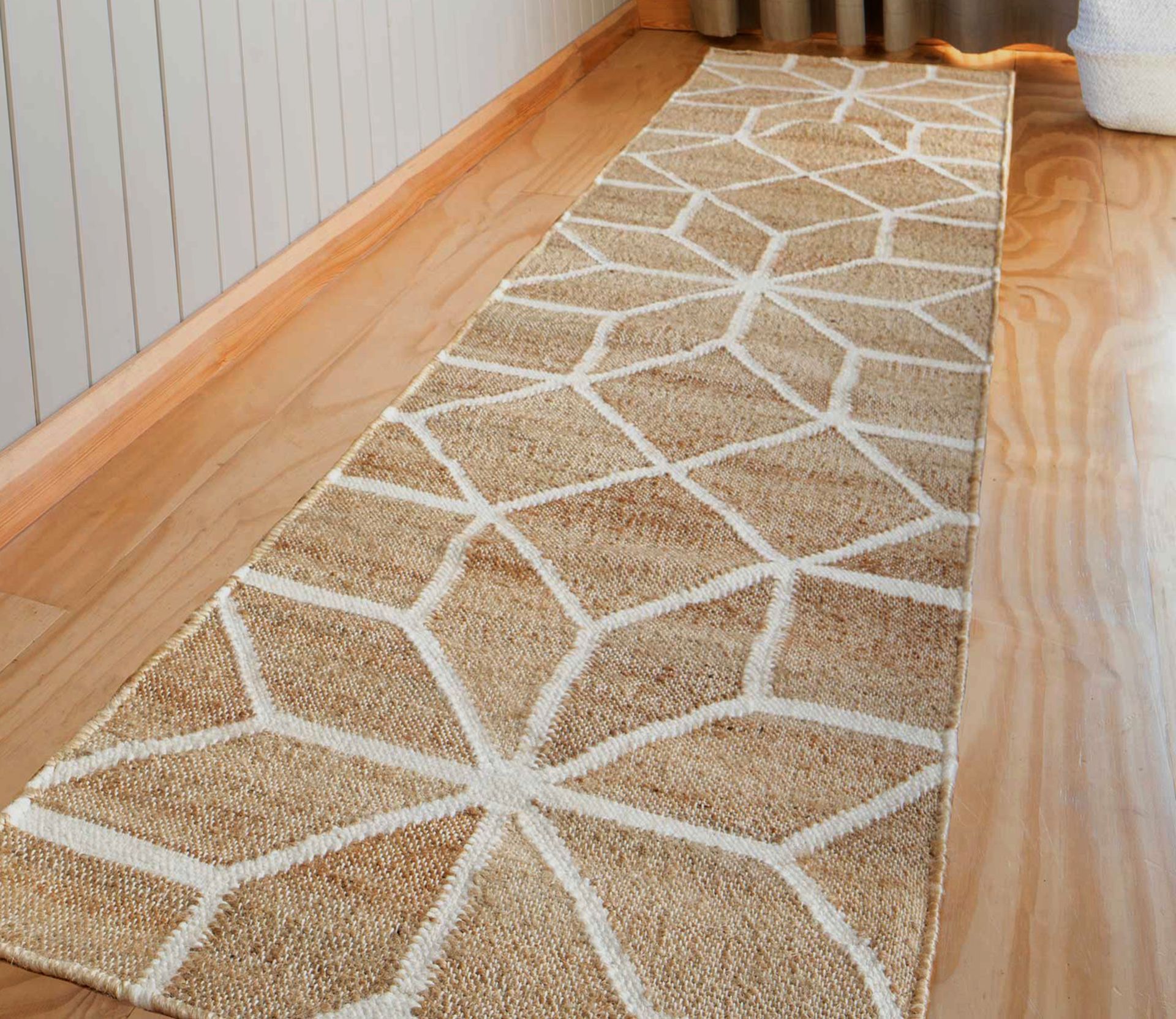 A rug with a geometric pattern is on a wooden floor.