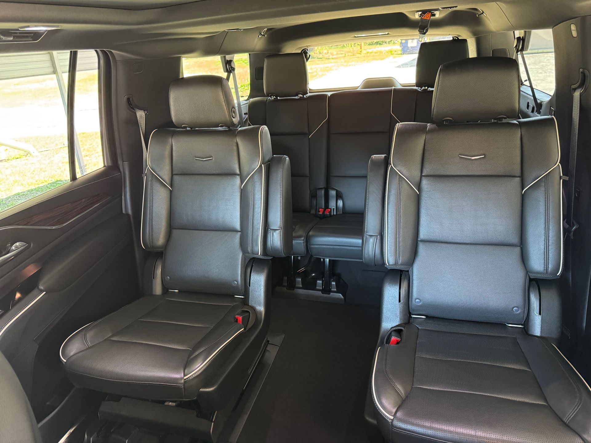 Black leather interior of a large SUV with captain's chairs and a rear bench seat.