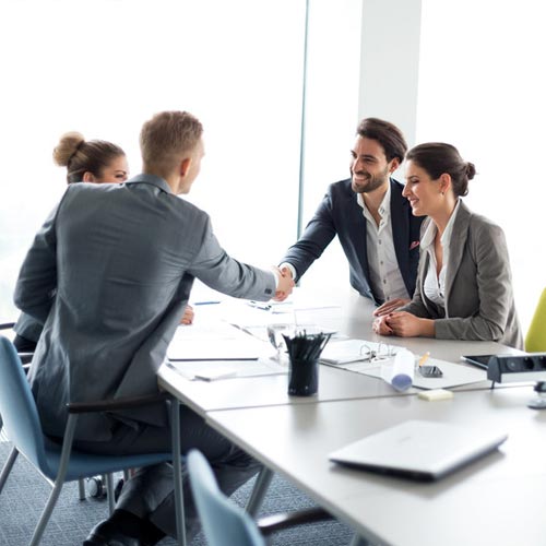 Happy couple meeting their financial advisor, shaking hands