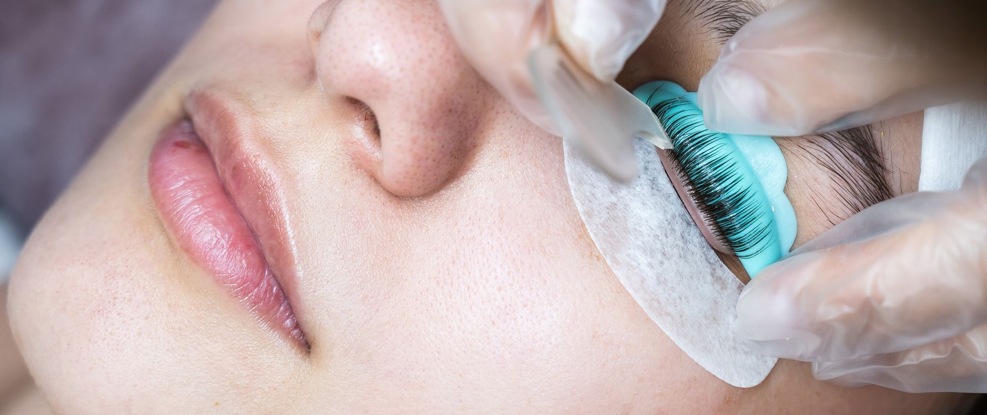 Close-up of a person's face, eye being treated during an eyelash lift procedure.