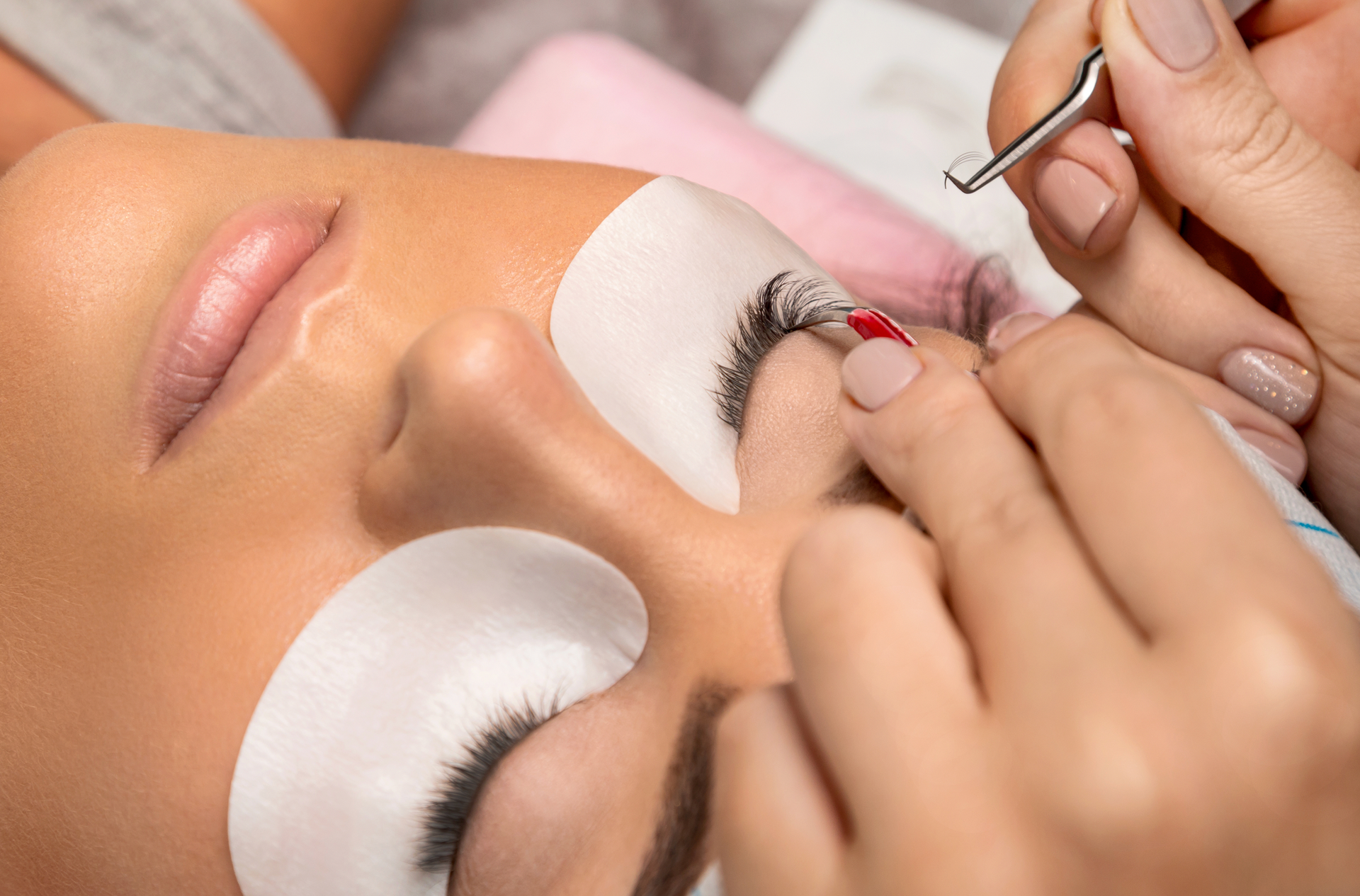 A woman is getting her eyelashes done at a beauty salon.